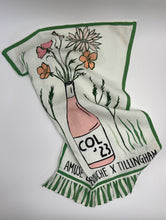Load image into Gallery viewer, Decorative towel with a bottle and floral design on a white background