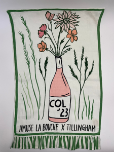 Tea towel with a bottle and flowers design, featuring 'COL '23' and 'Amuse La Bouche x Tillingham'.